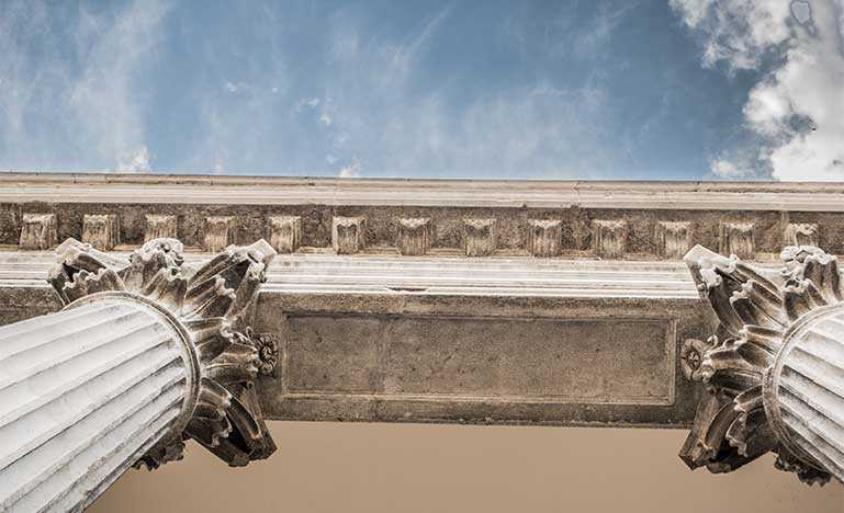 Looking up to the sky past court columns
