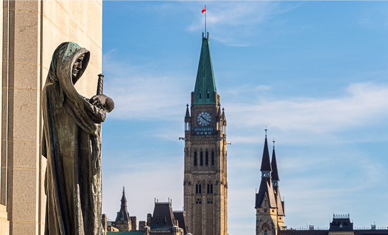 Statue with Parliament’s Peace Tower in Ottawa.