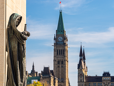 Statue with Parliament’s Peace Tower in Ottawa.