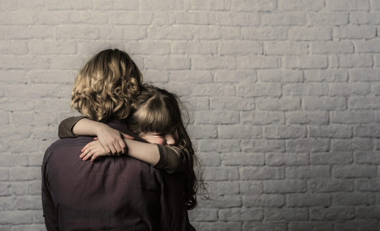 Single mother facing a wall