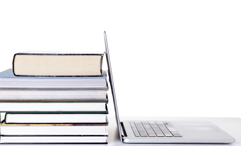 Open laptop screen leaning against a stack of books