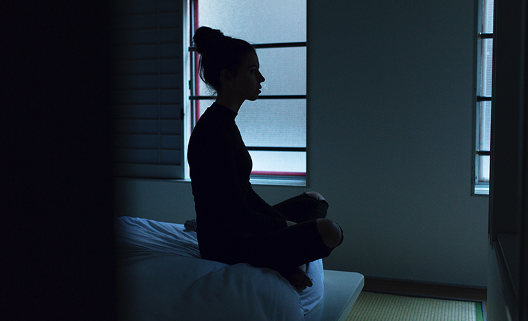 Woman sitting in the shadows
