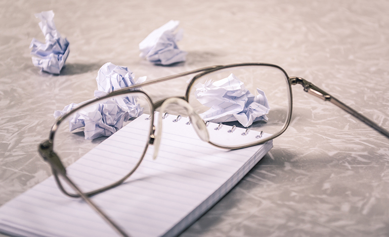 eyeglasses and crumpled paper