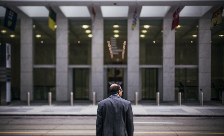 Man in front of large building