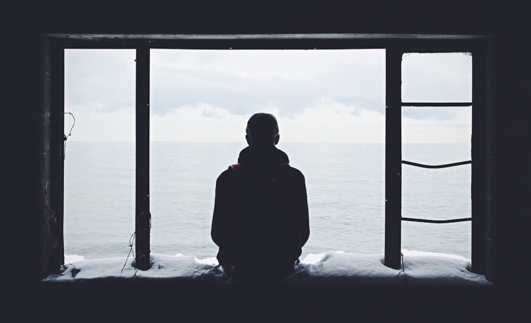 Silhouette of person staring out window