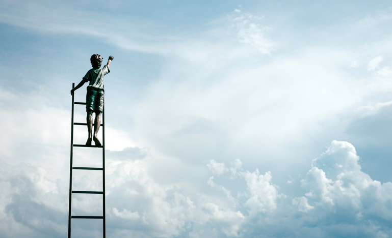 Boy on ladder reaching for the sky