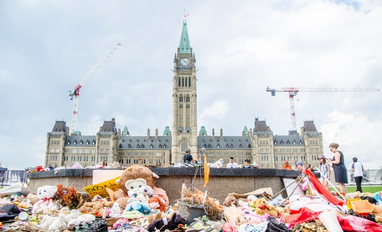 Ottawa Centennial Flame surrounded by flower and toys as a memorial for all the dead first nations children.