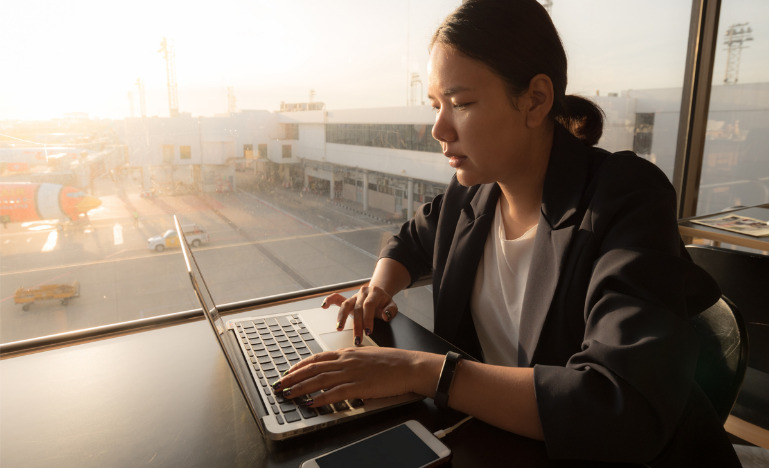 Vusiness woman working on laptop at airport
