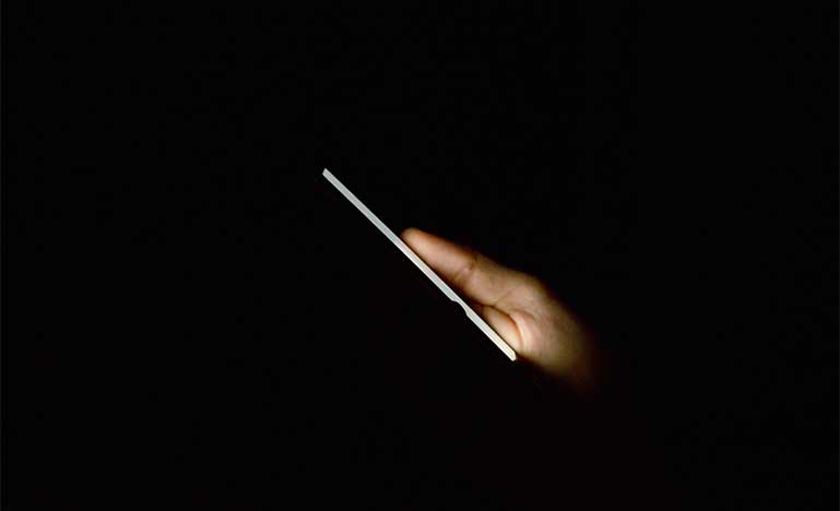 Man holding smartphone in the dark