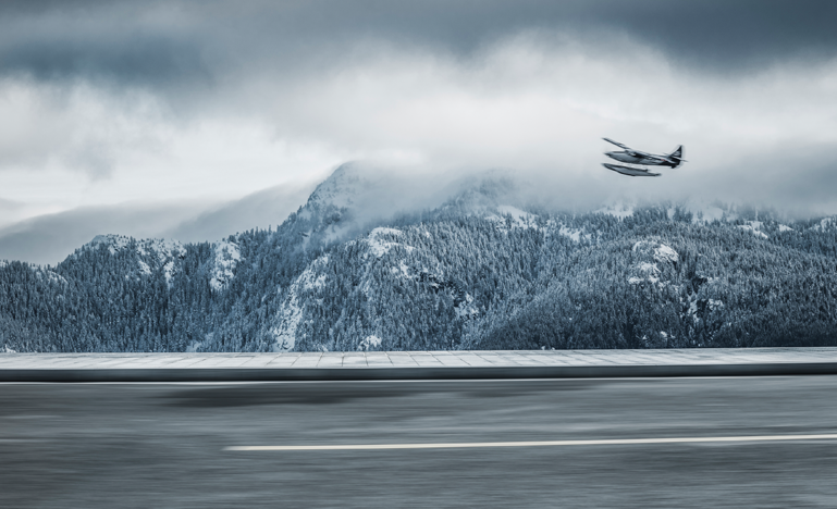 A small plane lands on a lake in the mountains in the Yukon.