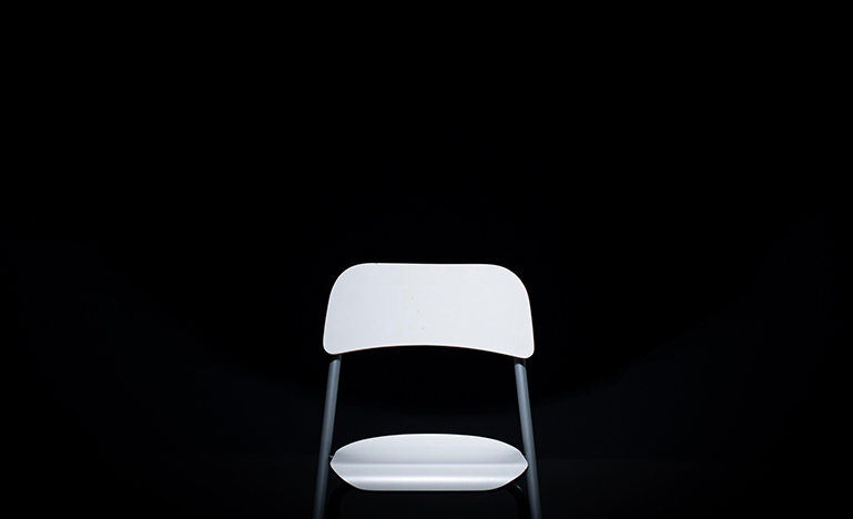 Empty white chair with black background