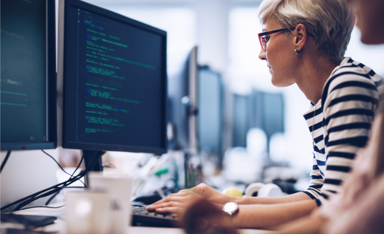 Profile view of young female programmer working on computer software