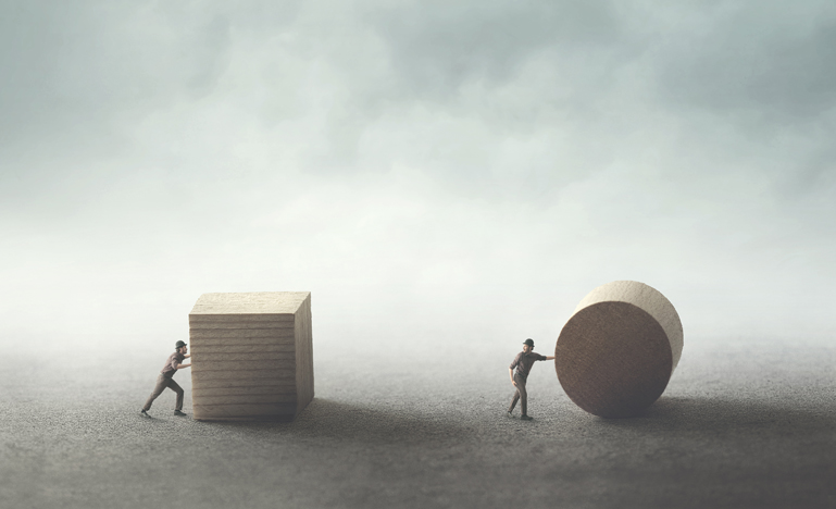 Men pushing different geometric wooden shapes