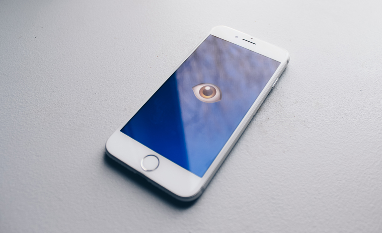 Image of phone on white background with an eye staring out to illustrate the privacy challenges presented by the use of AI