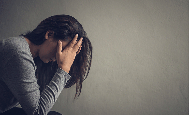 Depressed woman sitting with head in her hands