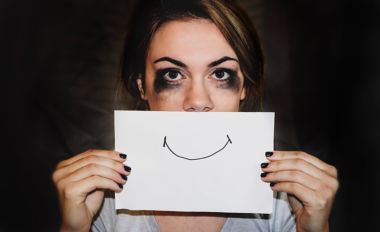 Image of woman holding paper in front of her face