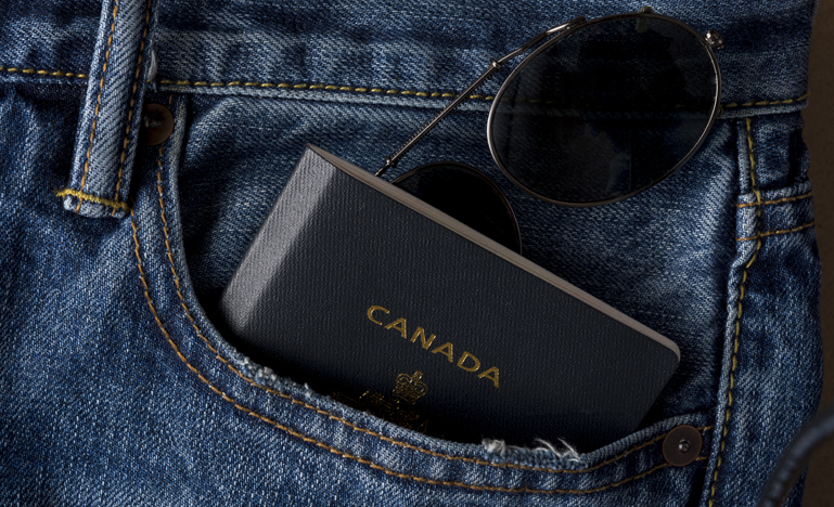 Canadian passport and sunglasses in jean pocket