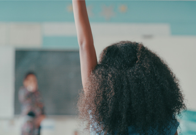 Child in class with hand raised