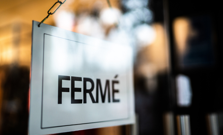 Un panneau « Fermé » dans la vitrine d'un commerce