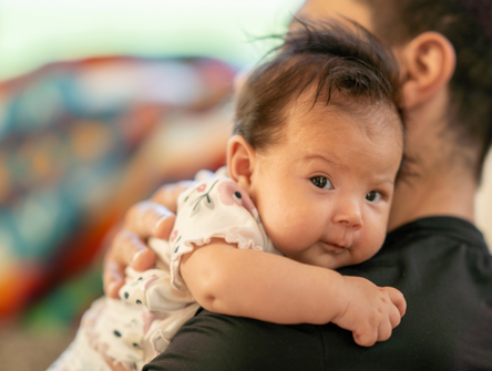An Indigenous baby in their father's arms