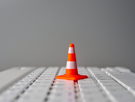 A minature caution cone on a computer keyboard