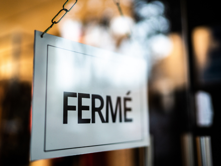 Un panneau « Fermé » dans la vitrine d'un commerce