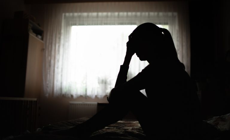 Grieving woman sitting on bed
