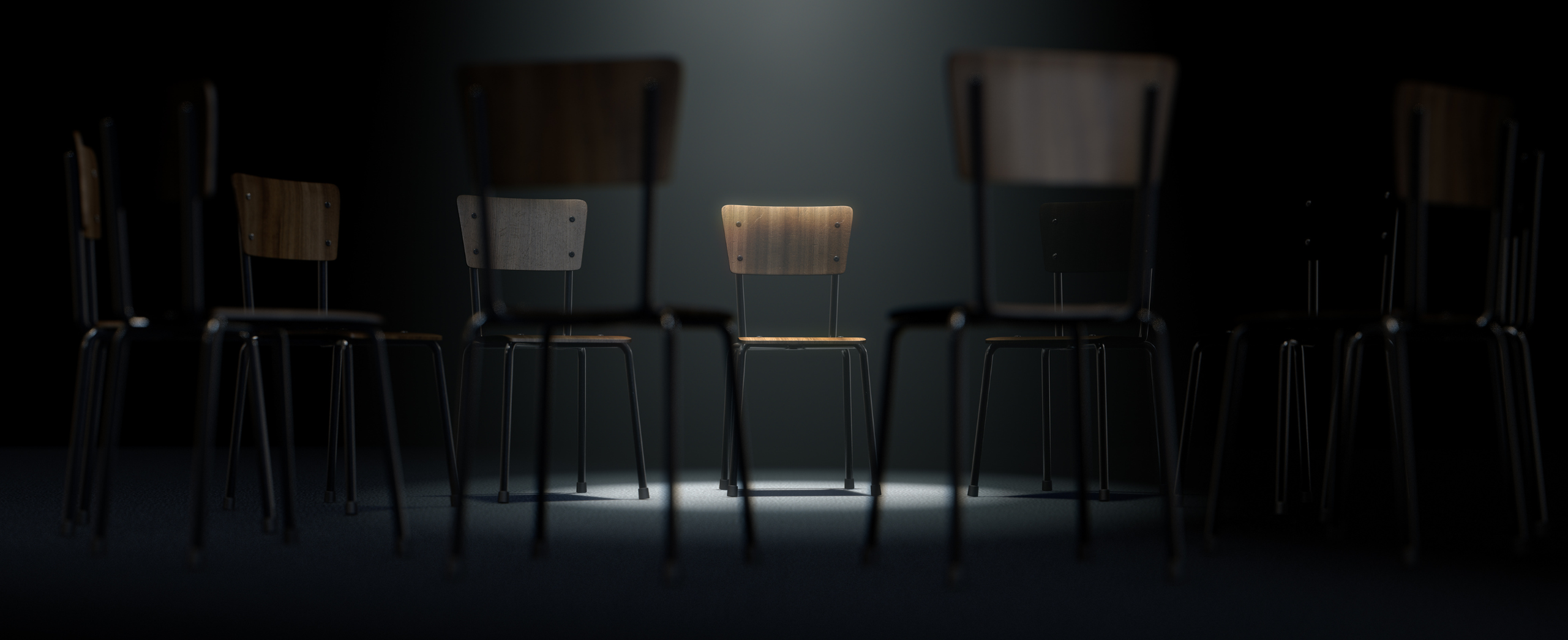 a group of chairs in a circular formation with one chair highlighted by a single spotlight on a dark background