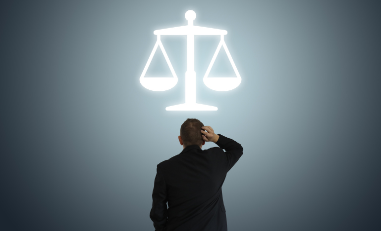 A business lawyer looks up at the scales of justice