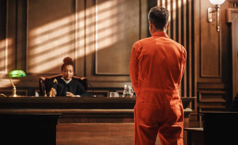 A prisoner stands before a judge in bail court