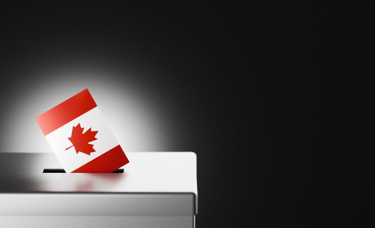 An image of a Canadian flag in the slot of a ballot box