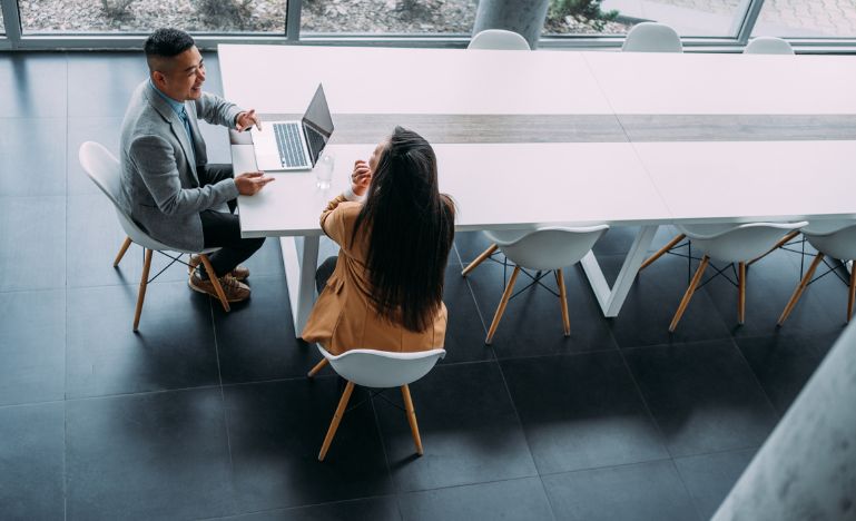 A lawyer and client meet at a board table