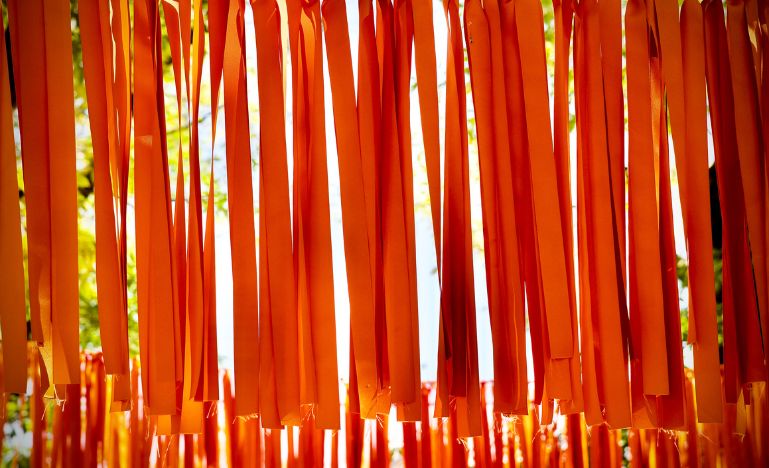 Orange string hanging from a wire to represent all the native children who died at a residential school in Canada.