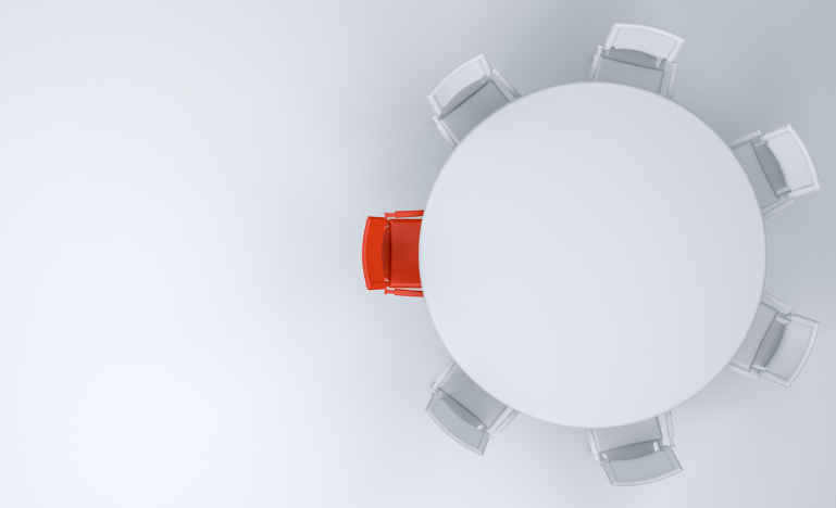 Une chaise rouge à une table entourée de chaises blanches