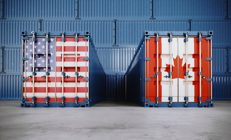 Cargo containers textured with American and Canadian flags before container wall