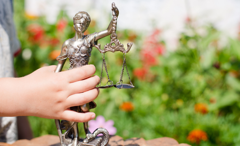A child's hand and the scales of justice