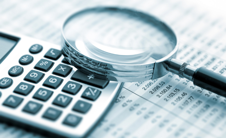 Calculator and magnifying glass with a spreadsheet