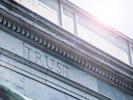 The word 'trust' etched into a stone courthouse