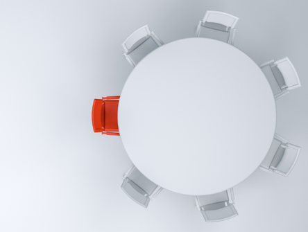 Une chaise rouge à une table entourée de chaises blanches