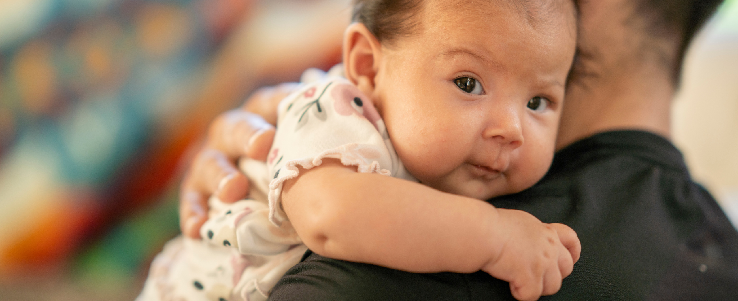 An Indigenous baby in their father's arms