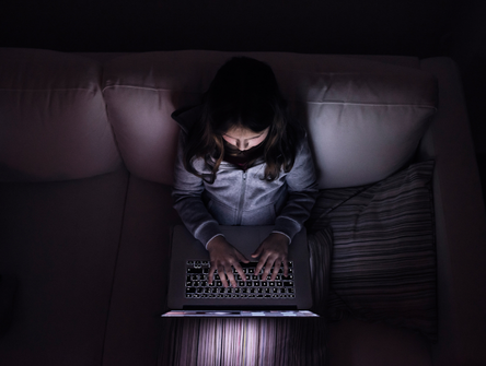 A child sits alone while on a computer
